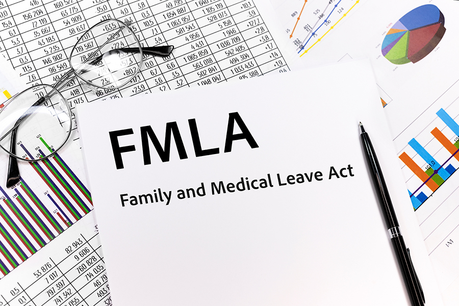 FMLA family medical leave act Concept. the inscription on the sheet. pen, glasses, documents, graphics.